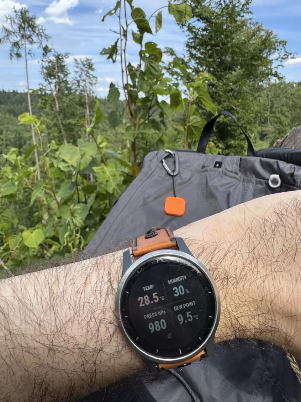 Senzor Thermio připnutý k batohu, zatímco hodinky Garmin na trase ukazují aktuální teplotu, vlhkost, tlak a rosný bod